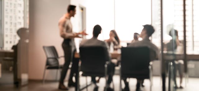 Workers standing in a conference room.